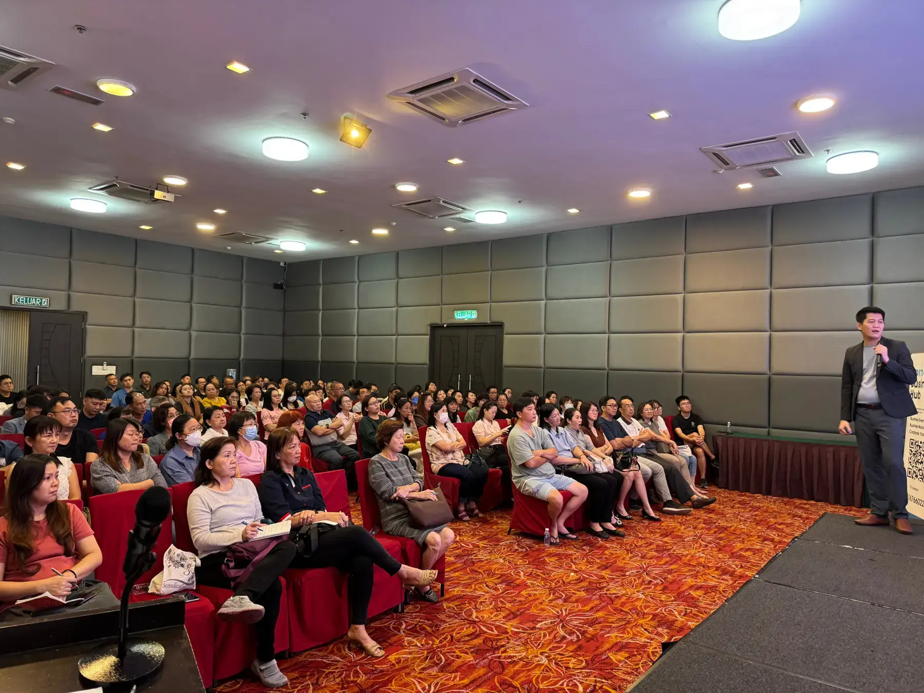 A speaker addressing a full seminar hall